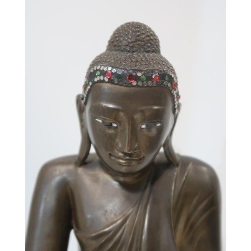 323 - A 20th century Burmese cast bronze Shakyamuni buddha, seated in lotus pose, wearing folded and pleat... 