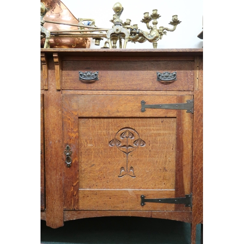 109 - An Arts & Crafts oak sideboard with pair of drawers over pair of cabinet doors carved with Arts ... 