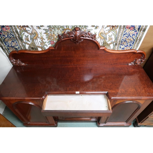 32 - A Victorian mahogany inverted breakfront sideboard with carved shaped backsplash over three cabinet ... 