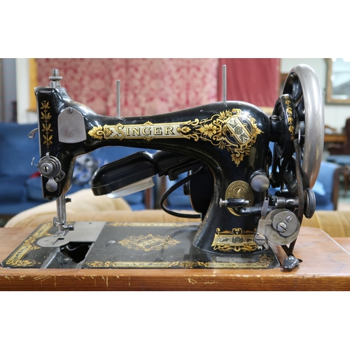 48 - A 20th century mahogany and walnut cased Singer treadle sewing machine, 79cm high x 87cm wide x 45cm... 