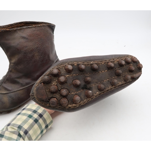 560 - A pair of leather boots with iron-studded soles, potentially of Chinese origin, together with a larg... 