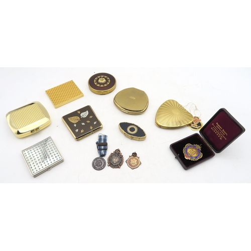 568 - A collection of powder compacts, to include an example with Scots Guards badge applied to lid, other... 