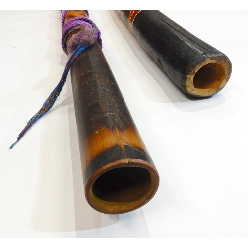 484 - A traditional aboriginal wood didgeridoo approximately 120cm together with a bamboo example 156cm (2... 