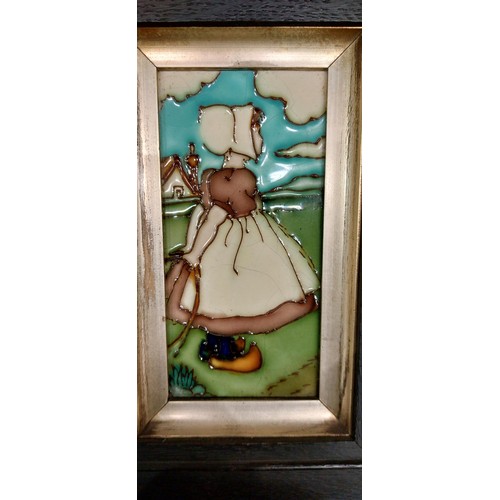 233 - A pair of tube lined tile plaques, depicting Dutch children, framed, possibly by Charlotte Rhead, to... 