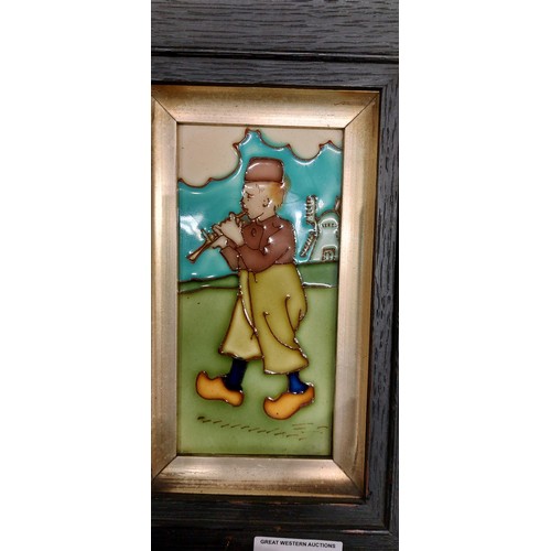 233 - A pair of tube lined tile plaques, depicting Dutch children, framed, possibly by Charlotte Rhead, to... 