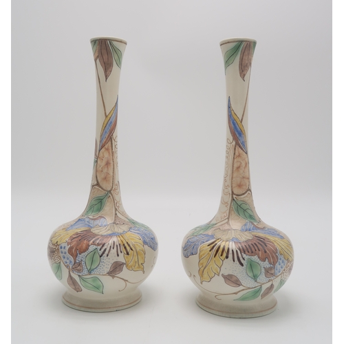 2153 - A PAIR OF GOUDA POTTERY VASESof bottle form painted with flowers and foliage, with painted marks and... 
