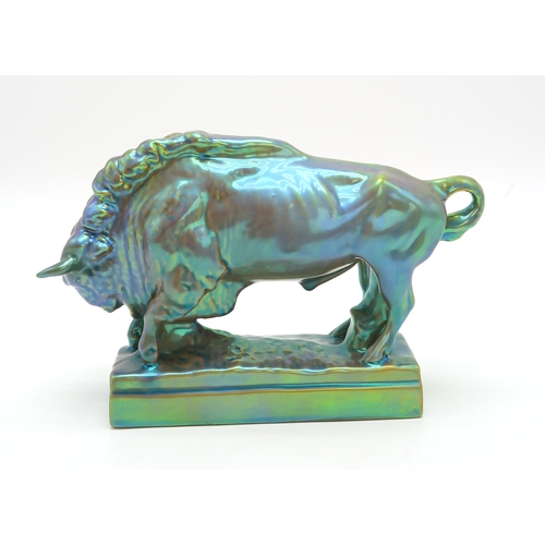 2156 - A ZSOLNAY PECS MODEL OF A BISONmodelled with head lowered, on rectangular base, with eosin iridescen... 