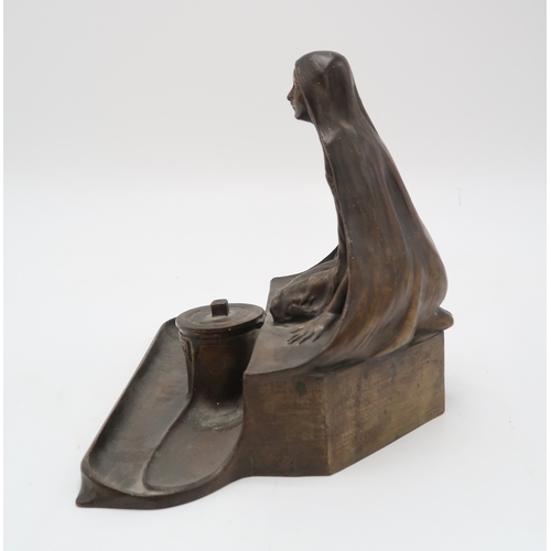 2174 - A CONTINENTAL ART NOUVEAU BRONZE INKWELL AND PEN TRAYmodelled as a kneeling maiden wearing a cloak, ... 
