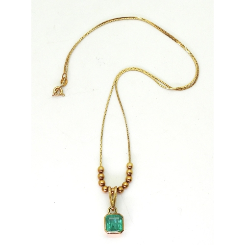 776 - An emerald pendant and chain with bead detail. The step cut emerald is approx 7.7mm x 7.5mm x 4.3mm,... 