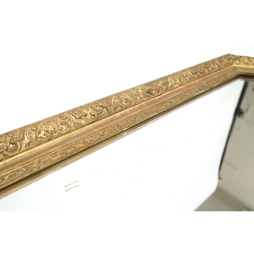 2004 - AN 18TH CENTURY STYLE GILT GESSO FRAMED WALL MIRROR with scrolled floral surmount over shaped mirror... 