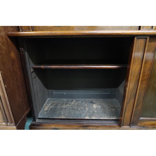 106 - A Victorian rosewood veneered glazed bookcase with moulded cornice over pair of glazed doors on base... 