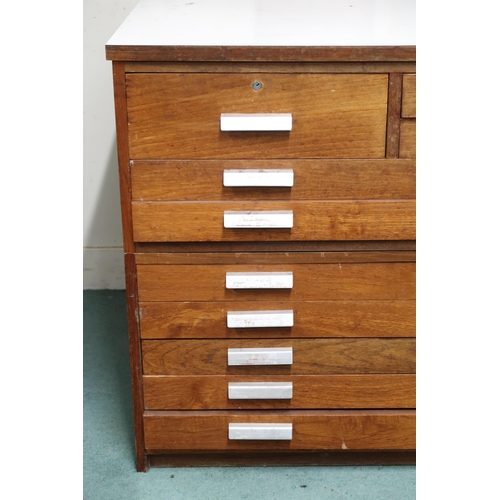 51 - A 20th century beech plan chest with Formica top over single drawer alongside two narrow drawers ove... 