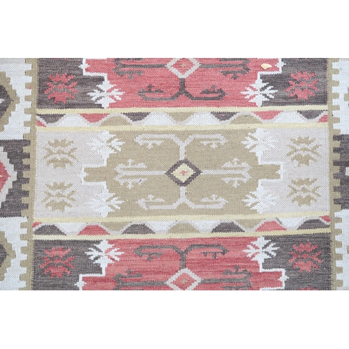 72 - A multicoloured ground tribal Kilim rug with geometric patterned ground, 188cm long x 123cm wide