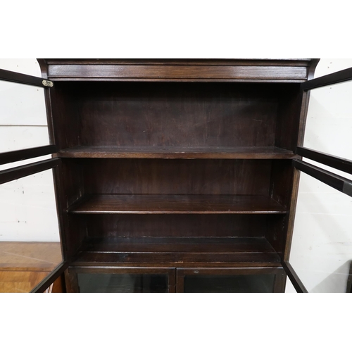 78 - A 20th century oak sectional bookcase with four pairs of glazed doors on turned supports, 175cm high... 