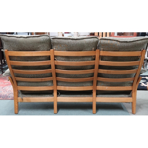 95 - A contemporary elm and beech framed Ercol three seater settee with green foliate upholstery, 97cm hi... 