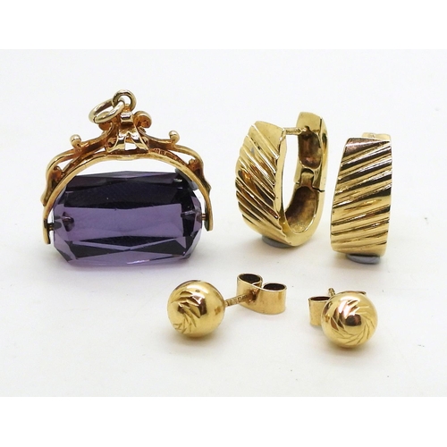 712 - A 9ct gold purple glass decorative fob seal, a pair of 9ct gold creole earrings and a pair of studs,... 