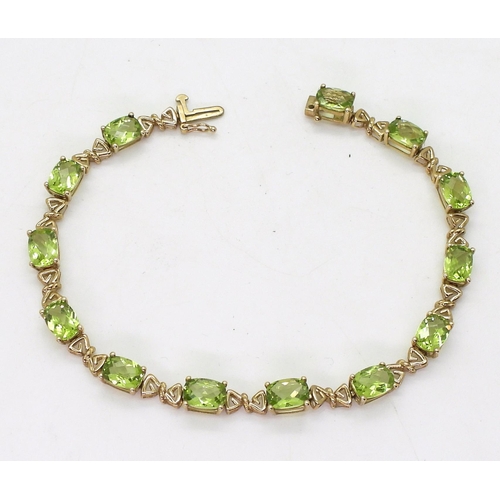 A 9ct gold peridot bracelet with decorative links, length 19cm, weight 9gms