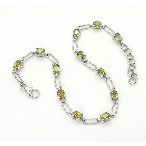 793 - A 10k white gold peridot bracelet, weight 6.5gms