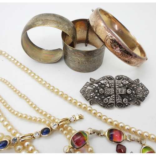 833 - A Sarah Coventry rainbow gem bracelet, a silver bangle, two silver napkin rings, and a deco clip, a ... 