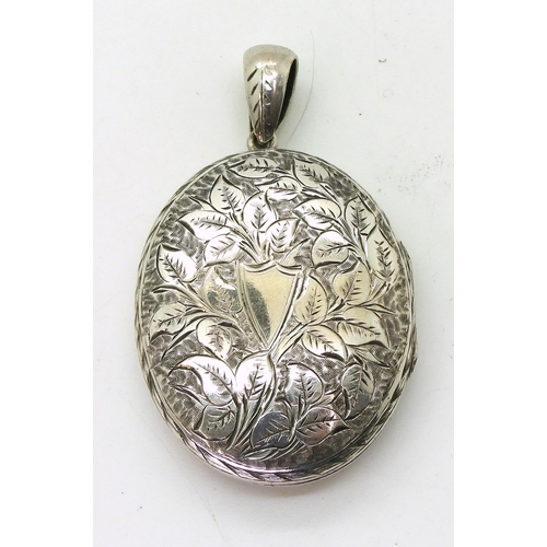 884 - A white metal large locket engraved all over with flowers and leaves, dimensions 5.5cm x 3.2cm