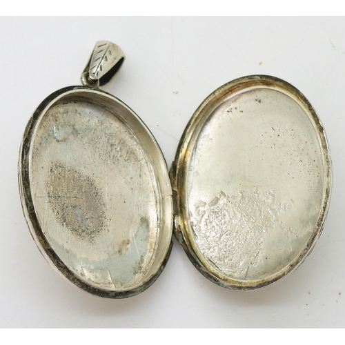 884 - A white metal large locket engraved all over with flowers and leaves, dimensions 5.5cm x 3.2cm