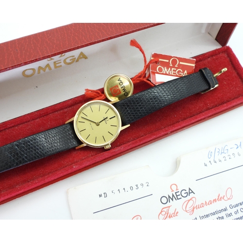 885 - A ladies gold plated Omega watch in original box, with swing tag and guarantee dated 1979