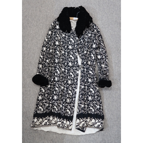 227 - An embroidered ladies coat, the black ground with white decoration and velvet frilled collar