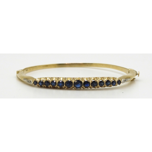 2719 - A SAPPHIRE AND DIAMOND BANGLEwith 9ct gold hallmarks for London 1987. Inner diameter 5.7cm x 5.2cm, ... 