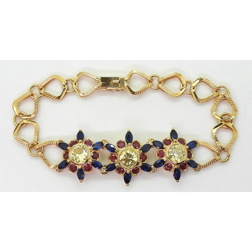 2723 - A 18CT GOLD FLOWER BRACELETthe three central flowers are set with sapphires, rubies and pale yellow ... 