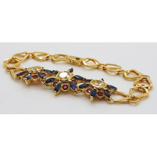 2723 - A 18CT GOLD FLOWER BRACELETthe three central flowers are set with sapphires, rubies and pale yellow ... 