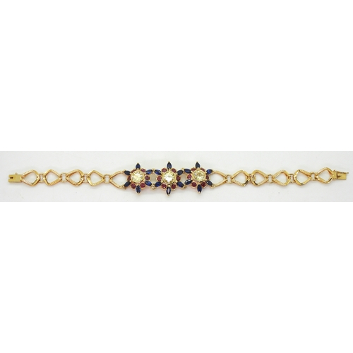 2723 - A 18CT GOLD FLOWER BRACELETthe three central flowers are set with sapphires, rubies and pale yellow ... 