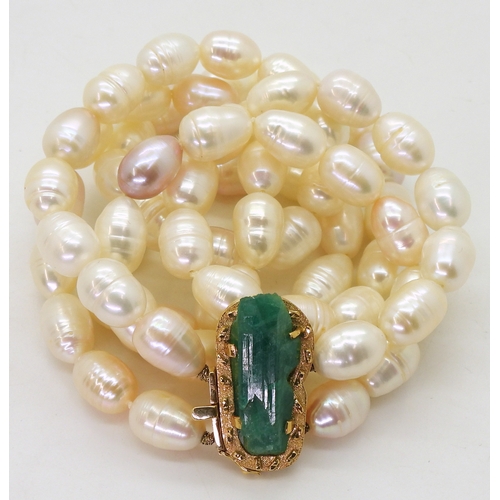 2731 - AN EMERALD AND PEARL NECKLACEthe bright yellow metal clasp is set with a natural raw emerald crystal... 