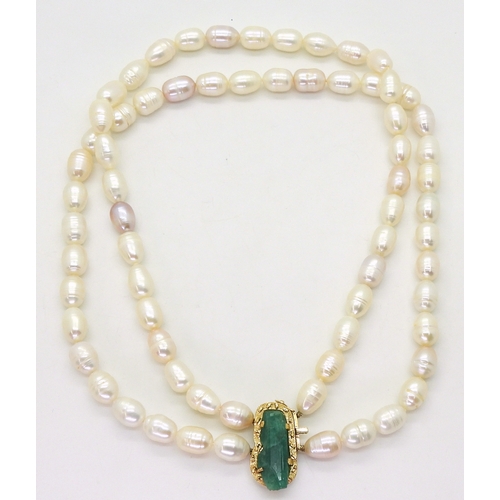 2731 - AN EMERALD AND PEARL NECKLACEthe bright yellow metal clasp is set with a natural raw emerald crystal... 