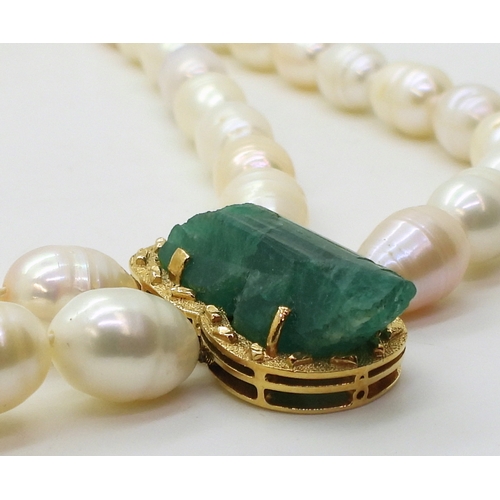 2731 - AN EMERALD AND PEARL NECKLACEthe bright yellow metal clasp is set with a natural raw emerald crystal... 