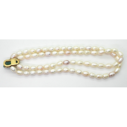 2731 - AN EMERALD AND PEARL NECKLACEthe bright yellow metal clasp is set with a natural raw emerald crystal... 