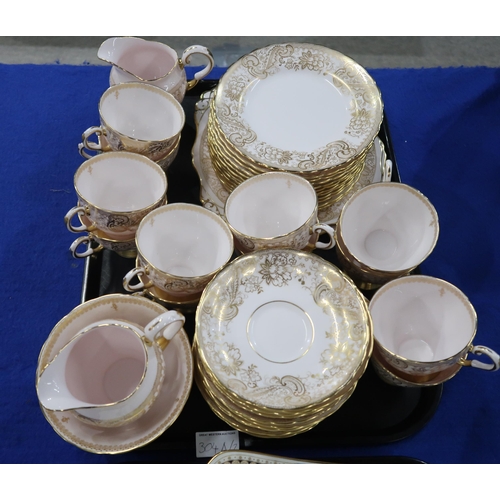 304A - A Tuscan pink ground tea set, pattern 8954H, gilt decorated with scrolling foliage, and a Cauldon te... 