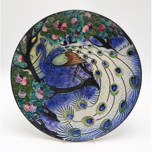 2180 - A CONTINENTAL POTTERY WALL PLATEwith tube line decoration of a peacock, 29.5cm diameter, together wi... 