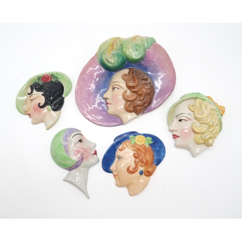 2186 - A COLLECTION OF ART DECO POTTERY WALL MASKSeach modelled as a woman's head, many by C Ltd including ... 