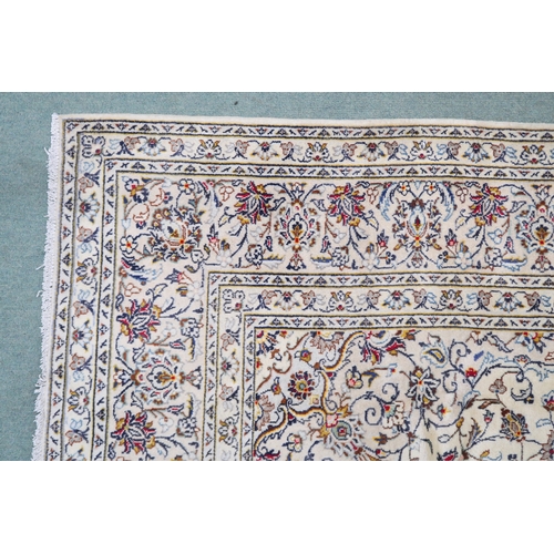 2130 - A CREAM GROUND KASHAN RUGwith flower head central medallion, matching spandrels and flower head bord... 