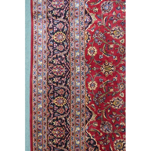 2132 - A RED GROUND KASHAN RUG With dark blue and cream diamond central medallion and matching spandrels on... 