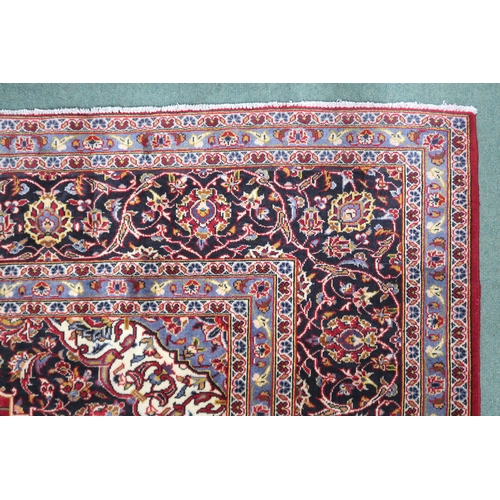 2132 - A RED GROUND KASHAN RUG With dark blue and cream diamond central medallion and matching spandrels on... 