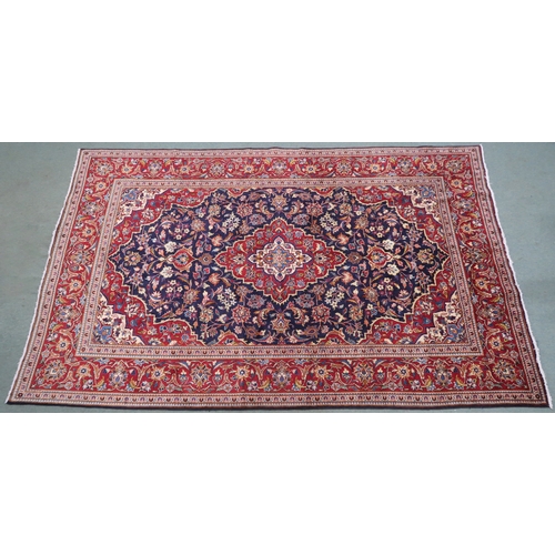 2134 - A DARK BLUE GROUND KASHAN RUGWith red and cream diamond central medallion and matching spandrels on ... 