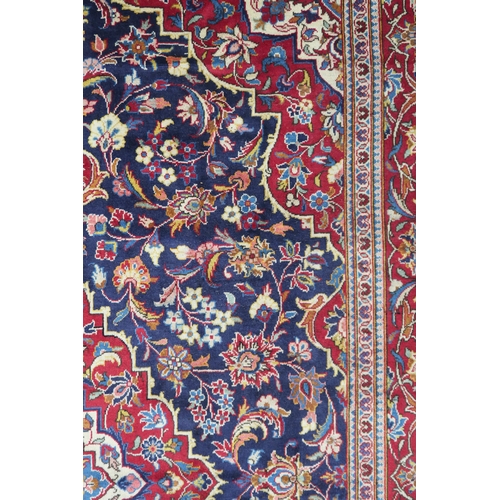 2134 - A DARK BLUE GROUND KASHAN RUGWith red and cream diamond central medallion and matching spandrels on ... 
