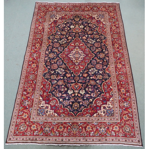 2134 - A DARK BLUE GROUND KASHAN RUGWith red and cream diamond central medallion and matching spandrels on ... 