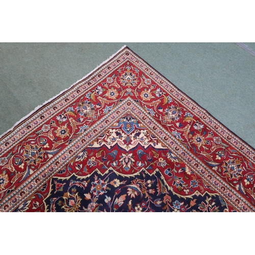 2134 - A DARK BLUE GROUND KASHAN RUGWith red and cream diamond central medallion and matching spandrels on ... 