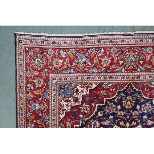 2134 - A DARK BLUE GROUND KASHAN RUGWith red and cream diamond central medallion and matching spandrels on ... 