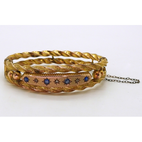 2734 - A 9CT EDWARDIAN BANGLEset with blue gems and rose cut diamond accents to the double barley twist ban... 