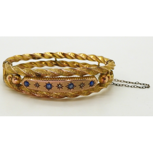 2734 - A 9CT EDWARDIAN BANGLEset with blue gems and rose cut diamond accents to the double barley twist ban... 