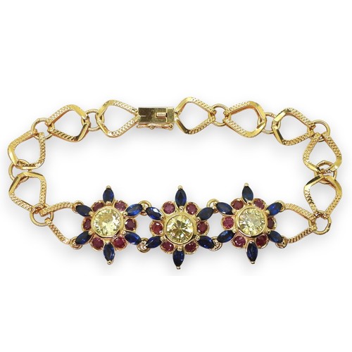 2723 - A 18CT GOLD FLOWER BRACELETthe three central flowers are set with sapphires, rubies and pale yellow ... 