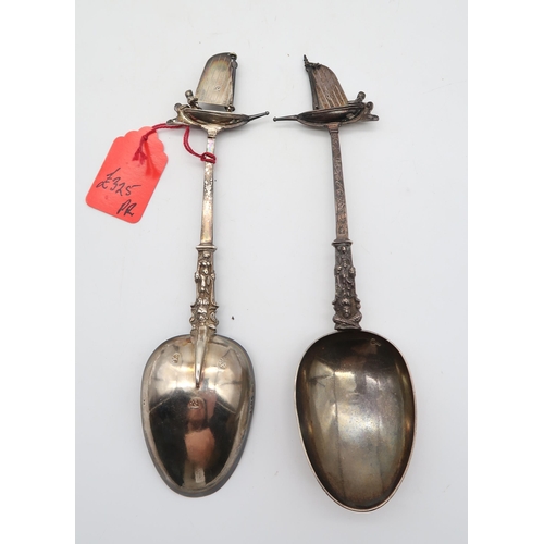 322 - A cased pair of Dutch silver serving spoons, with cast figural stems, engraved with scrolling foliat... 